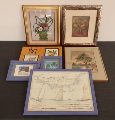 many framed pictures on a table with a picture of a sailboat
