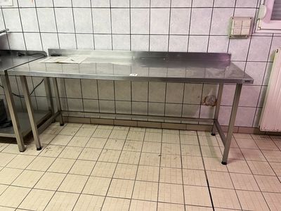 une table en acier inoxydable avec un évier au milieu de la pièce