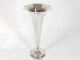 a silver vase that is sitting on a white surface