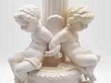 a white statue of two cherensils on a pedestal