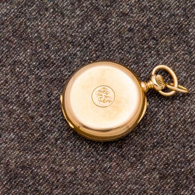 une montre de poche en or à laquelle est attachée une chaîne