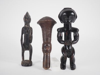 trois figurines en bois de formes et de tailles différentes posées sur une surface blanche