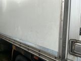 un camion blanc garé sur le bord de la route