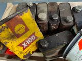 a box full of old oil cans and a can of gasoline