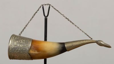 un cor auquel est suspendue une chaîne par l'embouchure