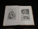 a book open on a table with drawings on it