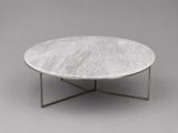 une table basse en marbre blanc avec un piètement en métal, sur fond gris