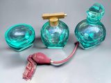 trois flacons de parfum posés sur une table, avec un cordon rouge