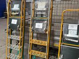 three metal racks with laptops on them in a warehouse