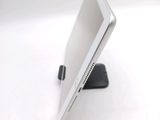a laptop computer sitting on a stand on a white surface