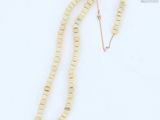 a close up of a necklace on a white surface