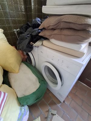 une pile d'oreillers posée sur une machine à laver