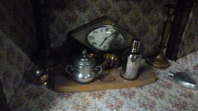 une table sur laquelle se trouvent une horloge et de l'argenterie