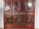 a wooden cabinet with many doors on it in a room
