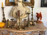 a bust of a woman sitting on top of a table next to candles