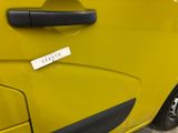 the door handle of a yellow car with a sticker on it