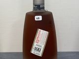 une bouteille d'alcool posée sur un comptoir à côté d'une autre bouteille d'alcool