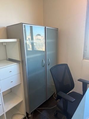 un bureau avec une chaise et un réfrigérateur dans un coin