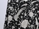 an image of a black and white shawl with white flowers and birds on it