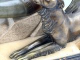 a statue of a person laying down with a dog