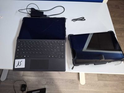 two laptops sitting on a table next to each other