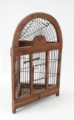 une cage à oiseaux en bois avec un oiseau à l'intérieur