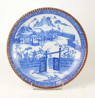 a blue and white plate with a mountain scene on it