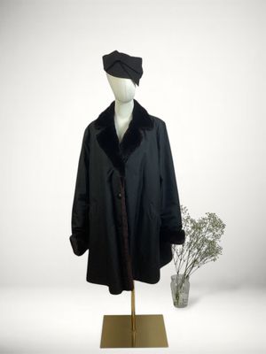 a mannequin wearing a black coat and a hat