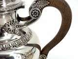 a silver tea pot with a wooden handle on a white background