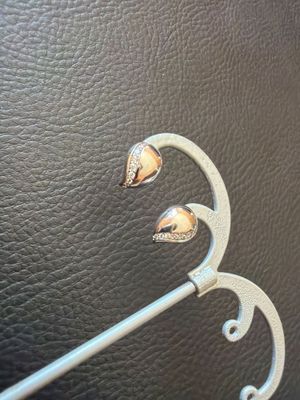 a close up of a metal hook on a black leather surface