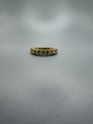 gros plan d'une bague en or sur une surface blanche