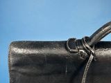 a close up of a black leather bag with a handle