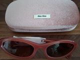 une paire de lunettes de soleil roses posée sur une table en bois