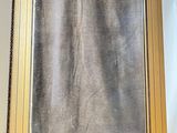 a picture of a gold framed mirror on a white wall