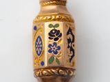 une image représentant un pendentif en forme de vase bleu et doré sur fond blanc