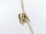 a picture of a gold necklace with a bird on it