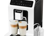 a white coffee machine with two cups of coffee next to it