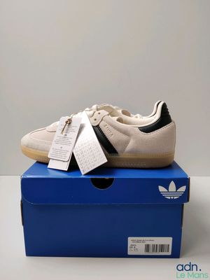 une paire de chaussures Adidas posée sur une boîte bleue