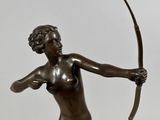 bronze statue of a woman holding a bow and arrow