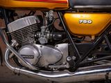 a yellow motorcycle parked in front of a brick wall