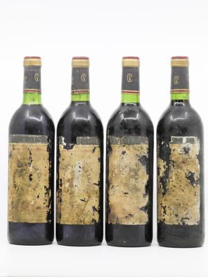 quatre bouteilles de vin sont alignées sur une surface blanche