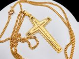 gold plated cross and chain necklace on a white plate