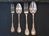four silver spoons and a fork on a black surface