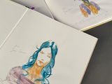 two drawings of a woman with blue hair in a book