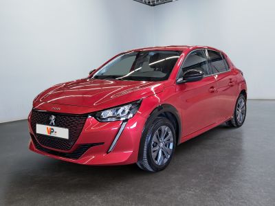 La voiture rouge est garée dans une grande pièce aux murs blancs.