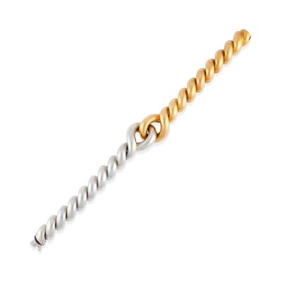 un gros plan d'un bracelet en or et en argent sur fond blanc