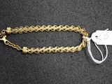 a gold chain bracelet with a tag attached to it