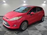 a red ford fiesta parked on a checkered floor in a garage