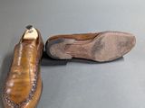 pair of men ' s brown leather slippers on a grey surface