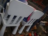 Plusieurs chaises en plastique sont empilées les unes sur les autres dans une pièce